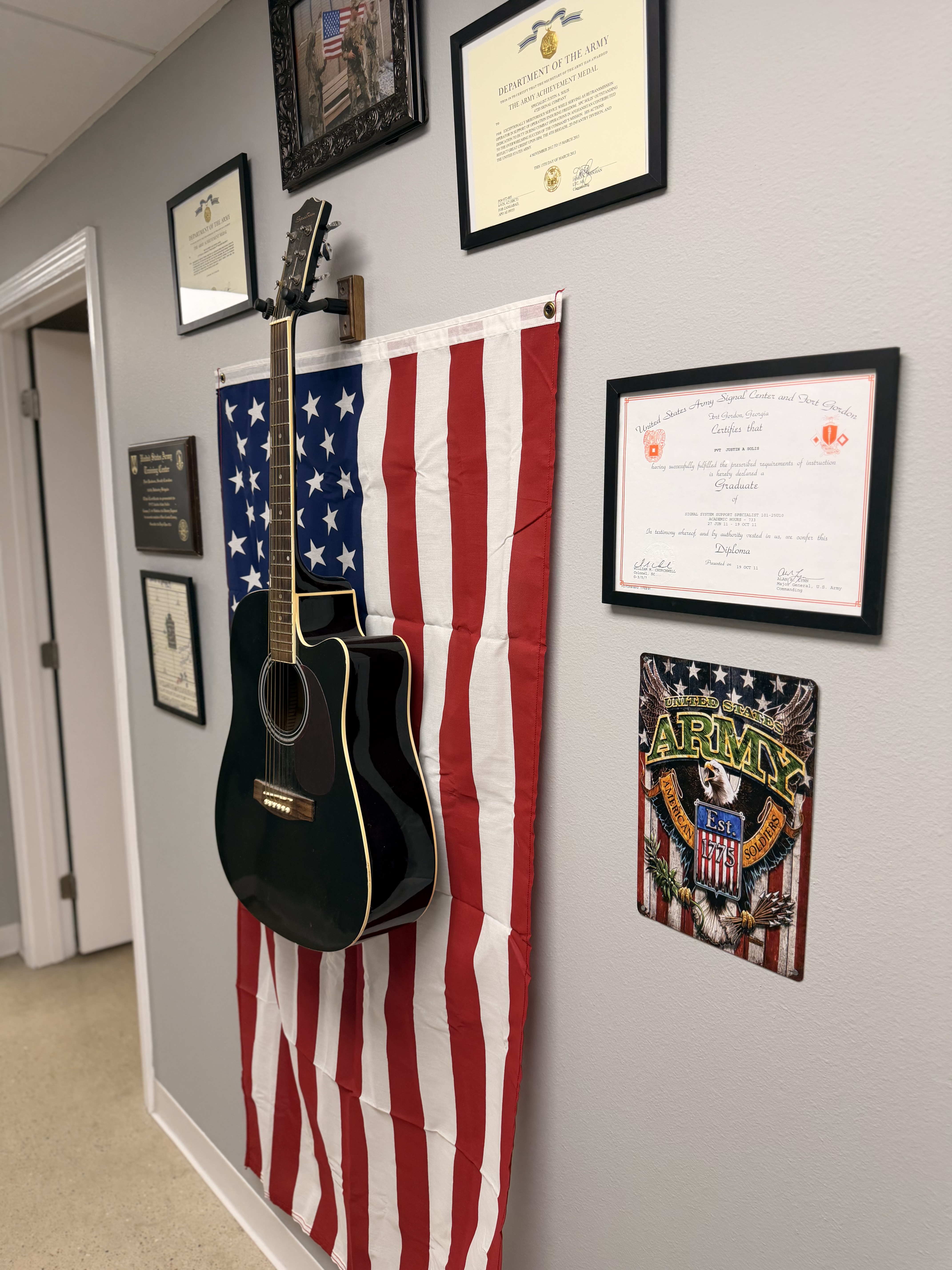 Veteran-owned tattoo shop Conway AR - military wall with American flag and Army certificates