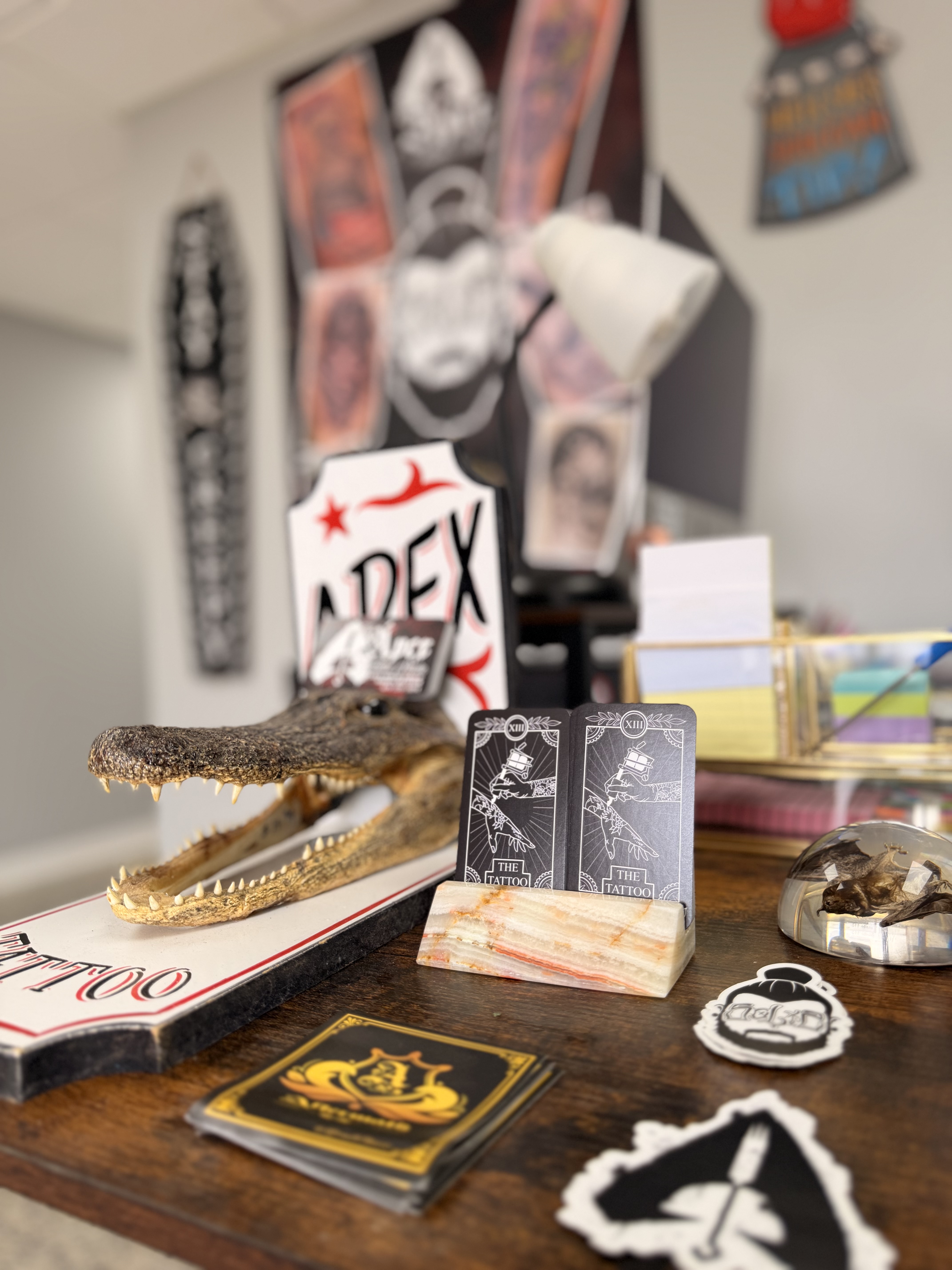 Waiting area at Apex Tattoo Conway AR with art wall and TV